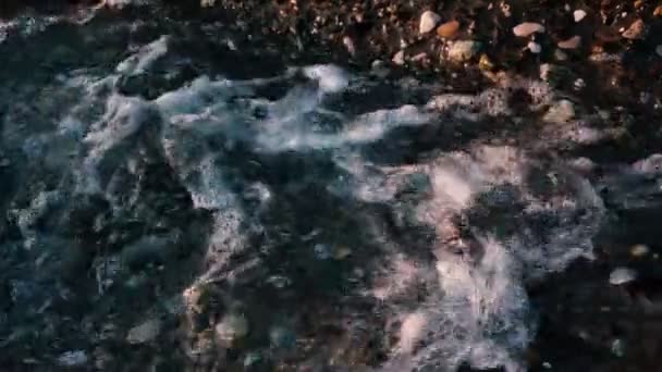 La cámara lenta de un arroyo de montaña fluye hacia el mar al atardecer de cerca — Vídeo de stock