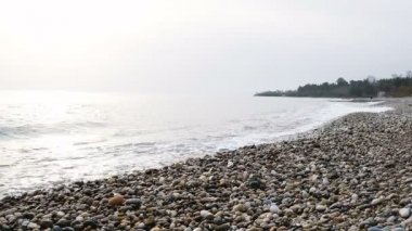 Dalgalar deniz ağır çekim yakın çekim çakıl plaj üzerine dökülen