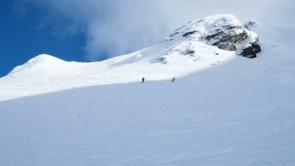 Rallentatore due sciatori cavalcano dalla cima della montagna, freeride in montagna — Video Stock