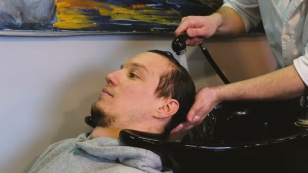 Cabeleireiro lava um homem cabeça na barbearia — Vídeo de Stock