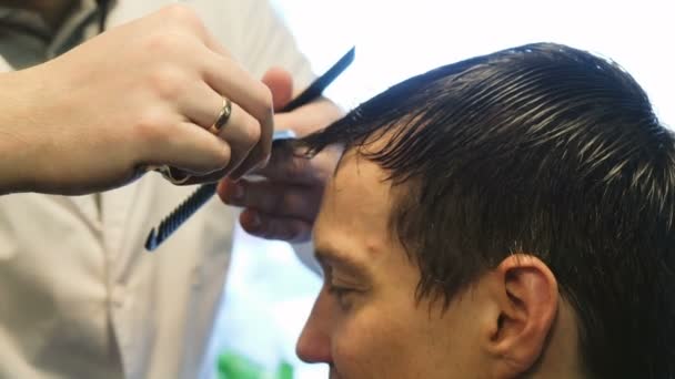 Kapper knipt een man met een scheermes in de barbershop — Stockvideo