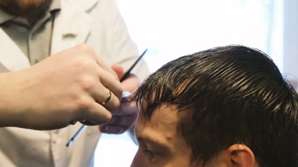 Kapper knipt een man met een scheermes in barbershop close-up — Stockvideo