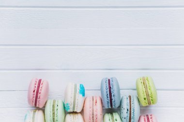Tanımlama bilgilerini macaron veya macaroons veya Badem Çerezler Dama Tahtası deseni üstten görünüm yakın çekim, kopya alanı bir ahşap beyaz arka plan üzerinde yalan