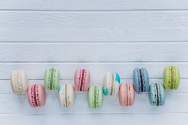 Tanımlama bilgilerini macaron veya macaroons veya Badem Çerezler Dama Tahtası deseni üstten görünüm, kopya alanı içinde ahşap beyaz bir arka plan üzerinde yalan