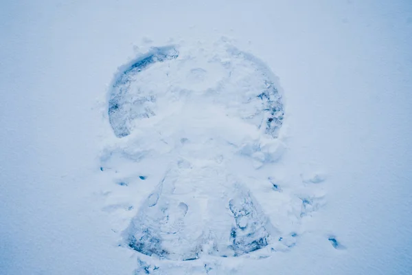 Ángel de nieve en la nieve, dibujando en el suelo en el frío invierno —  Fotos de Stock