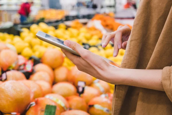 Ділова жінка з планшетом купує їжу в супермаркеті — стокове фото