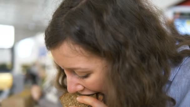 Mujer europea comiendo pescado y verduras sándwich de cerca — Vídeo de stock