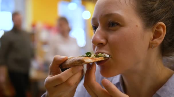 若いです女の子食べるジューシーな熱いですスライスのピザ — ストック動画