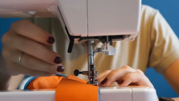 Perto de uma costureira costura uma peça de roupa em uma máquina de costura — Vídeo de Stock