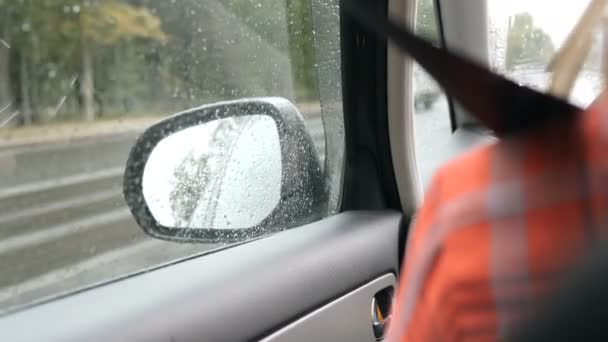 Rétroviseur de la voiture sous la pluie, la voiture se déplace sur l'autoroute — Video