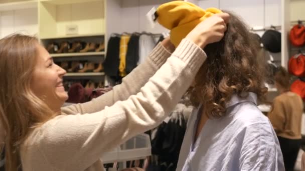 Dos mejores amigos tontean en una tienda de ropa — Vídeos de Stock