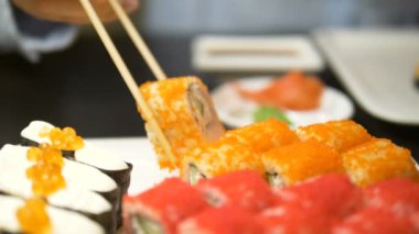 Kadın turuncu havyarla kaplanmış harika bir rulo alıyor.