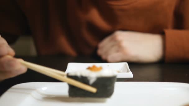 Mãos homem colocar sushi em molho de soja e cara come vista de perto — Vídeo de Stock