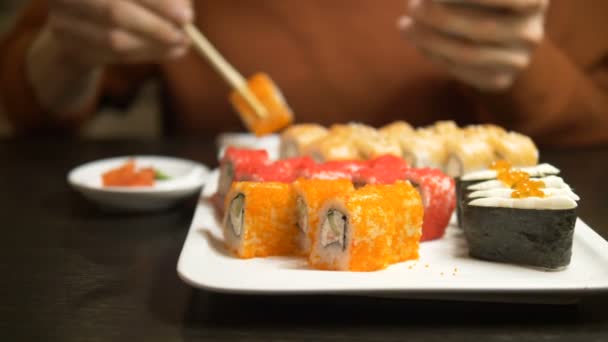 Hombre charlando en línea come sushi roll cubierto de caviar — Vídeo de stock