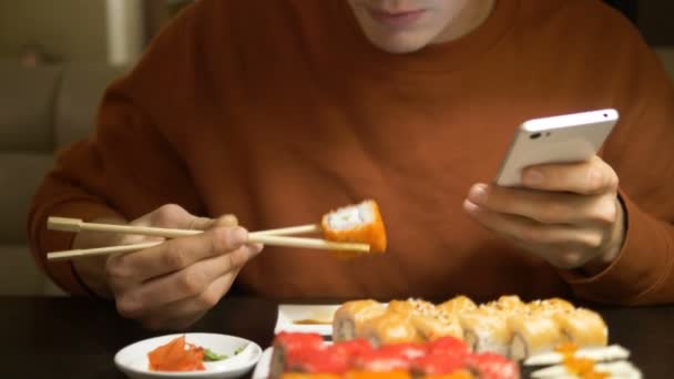 Srác csinál szelfi fehér okostelefon evés közben sushi — Stock videók