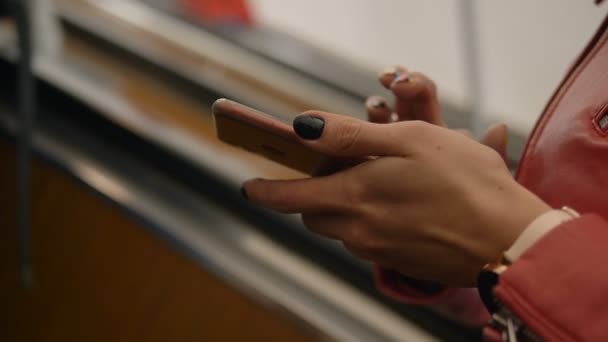 Manos de chica con clavos negros sostienen el teléfono montando en escaleras mecánicas — Vídeos de Stock