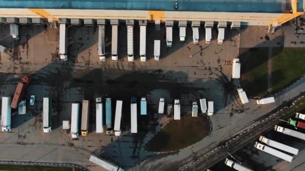 Flycam films grote vrachtwagens staan in rij bij het laden poorten — Stockvideo