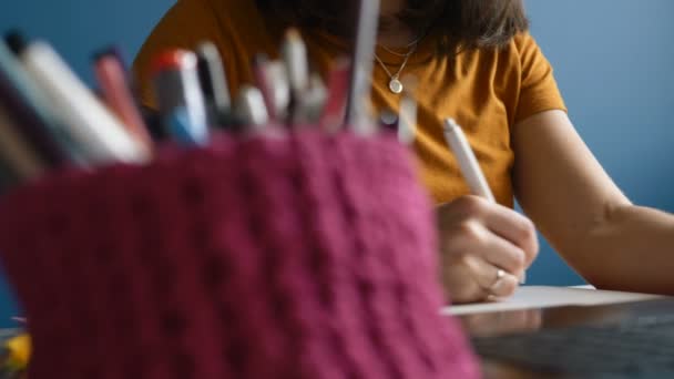 Mujer diseñadora dibuja un proyecto en una tableta gráfica mientras está sentada en una computadora en el lugar de trabajo — Vídeos de Stock