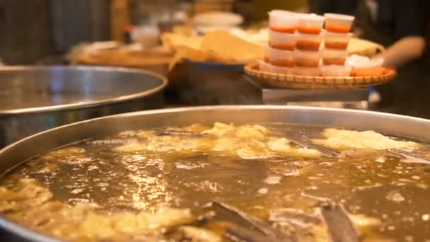 Bouillon de bœuf savoureux bout dans un grand pot en métal contre les cuisiniers — Video