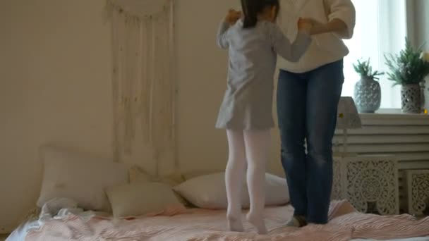 Mor och dotter hoppar på vit säng och dam spyr upp unge — Stockvideo