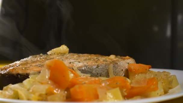 Weißer Dampf über zubereitetem roten Fisch mit Zwiebel und Karotte — Stockvideo