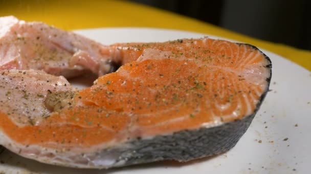 Skilled cook prepares raw red fish sprinkling and smearing — Stock Video