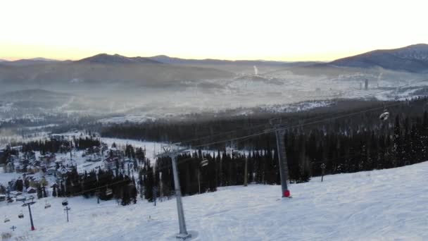 Long chairlift moves over white snow on ski resort territory — Stock Video