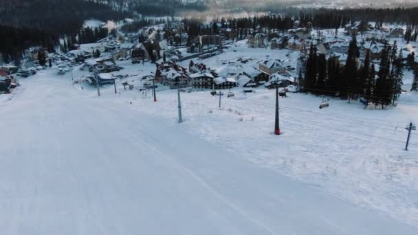 Domaine skiable avec télésiège moderne et petits bâtiments hôteliers — Video