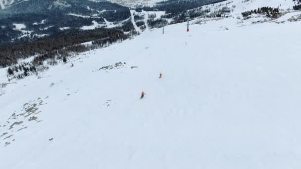Estación de esquí siluetas de los visitantes tren en pista de nieve ancha — Vídeo de stock