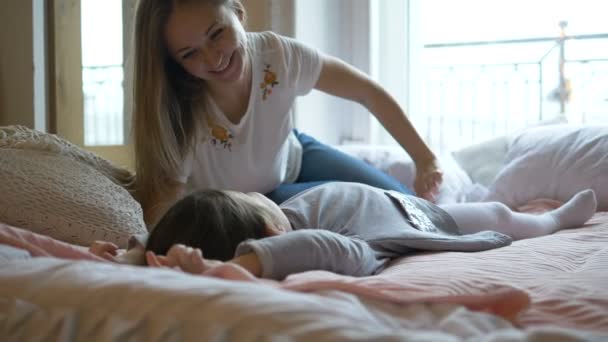 Bela loira e filha mentira em cama grande e jogar — Vídeo de Stock