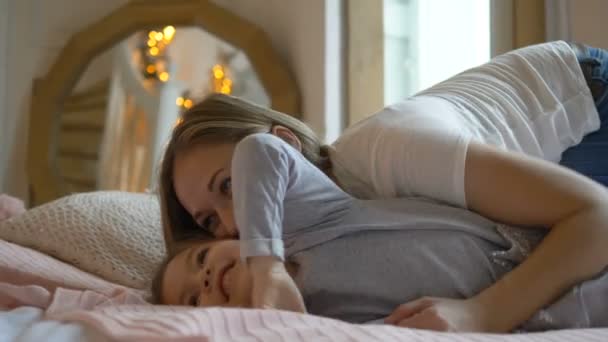 Mutter und Tochter albern im Bett herum, lachen und kitzeln sich gegenseitig — Stockvideo