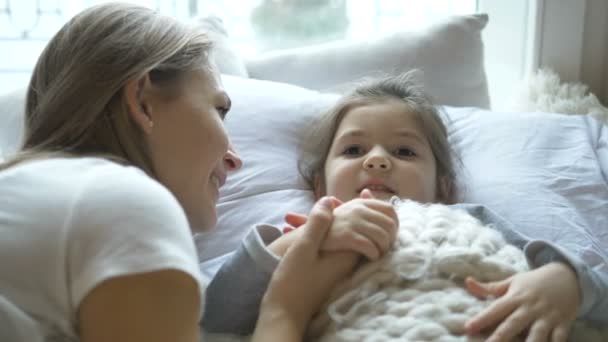 Υπέροχη μητέρα και κόρη επικοινωνούν ξαπλωμένοι στο κρεβάτι — Αρχείο Βίντεο