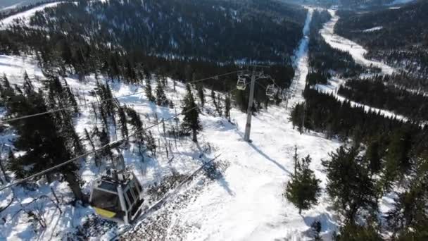 Cabines de teleférico de esqui modernos se movem sobre trilhas extremas na colina — Vídeo de Stock