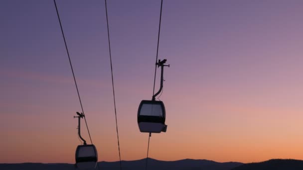 Silhouettes cabine de téléski modernes se déplacent contre le coucher du soleil — Video