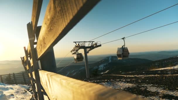 Große Kabinen bewegen sich an Skiliftdrähten gegen neblige Hügel — Stockvideo