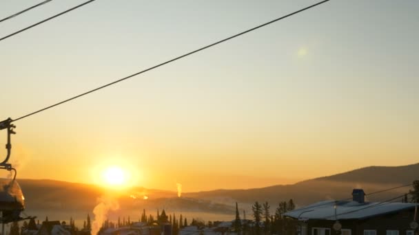 Kayakçılar modern kayak asansöründe oturur ve tatil köylerinin üzerinden geçerler. — Stok video