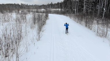 Ormandaki karlı yolda profesyonel atlet gökyüzü