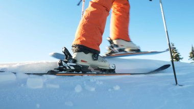 Kayakçı bozulmamış beyaz kar boyunca hareket eder. Düşük açılı çekim yakın.