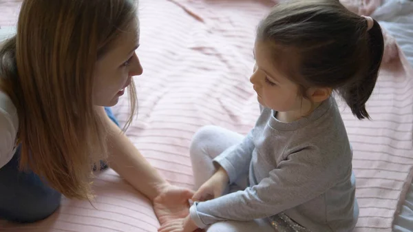 Biondo dai capelli lunghi parla con la piccola figlia che si unisce le mani — Foto Stock