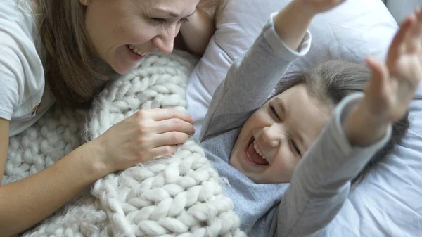 Signora sorridente con i capelli biondi parla al bambino e tocca il naso — Foto Stock