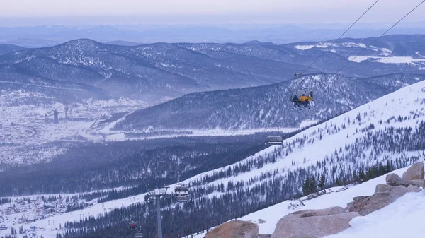 Skifahrer am Sessellift bewegen sich auf hohem Hügel im schönen Hochland — Stockfoto