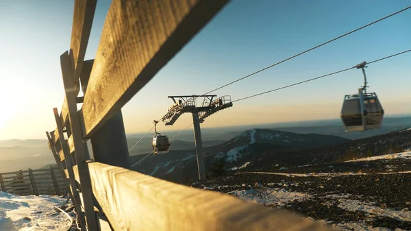 Große Kabinen bewegen sich an Skiliftdrähten gegen neblige Hügel — Stockfoto