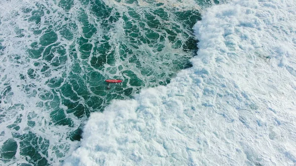 Surfer jest przykryty i porwany przez dużą falę oceaniczną, przeniesiony z powrotem na brzeg, widok z powietrza — Zdjęcie stockowe