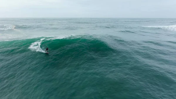 Surfista desliza sobre ondas gigantes do oceano vista aérea — Fotografia de Stock