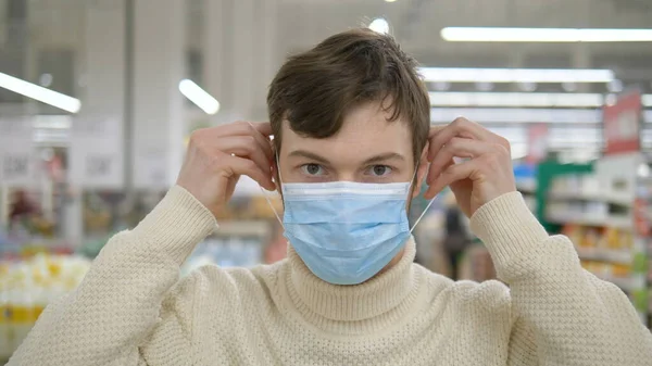 Молодий чоловік одягає медичну маску, щоб захистити себе від епідемії — стокове фото