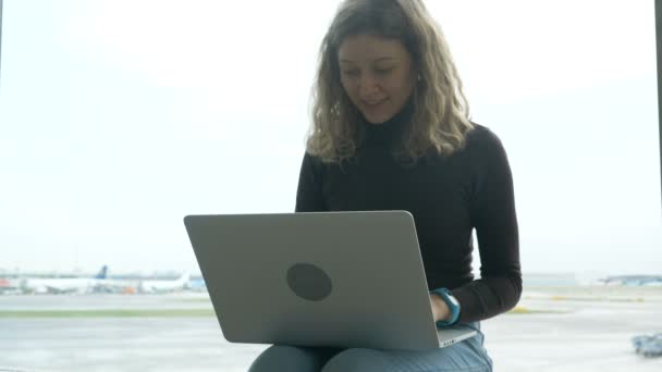 Senhora com laptop contra grande janela no lounge do aeroporto — Vídeo de Stock