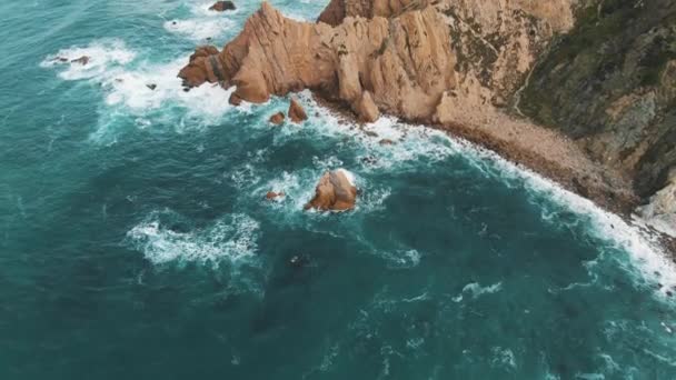 Rotsachtige kust bedekt met gras in de buurt van azuurblauwe oceaan luchtfoto — Stockvideo