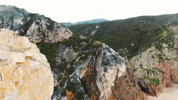 Volo sopra scogliera marrone che sale sopra l'oceano formando schiuma — Video Stock