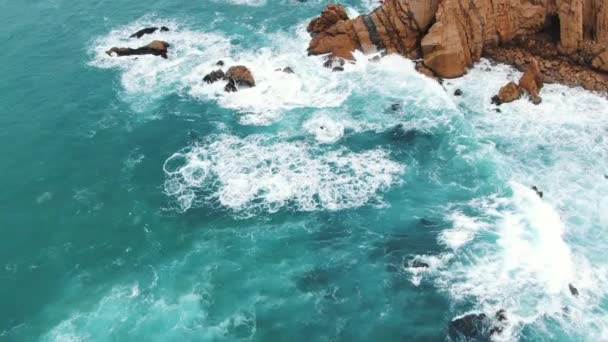 在陡峭的岩石海滩上翻滚的蓝色波浪上的空中运动 — 图库视频影像