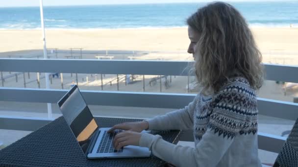 Señora freelance trabaja en proyecto sentado contra la playa de arena — Vídeo de stock